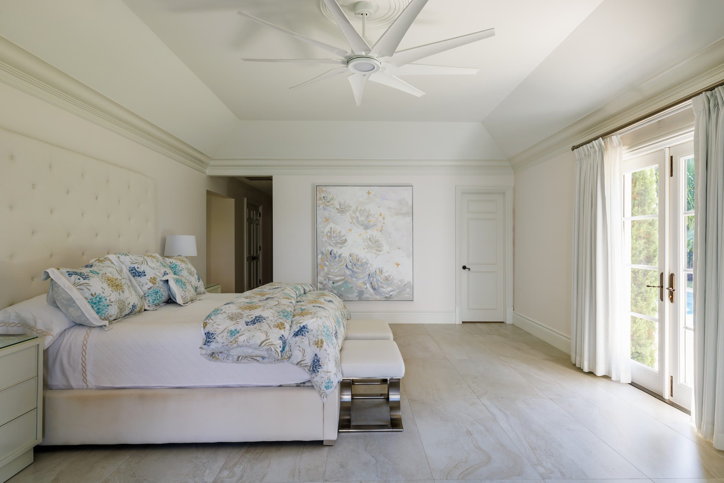 A commissioned Carol Calicchio painting hung above a bed in a collector's home